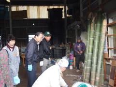 壁際に立ててある竹を機械を使い加工している竹宵の会の方の写真