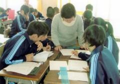 中学生がグループごとに分かれ、点訳ボランティアの方が学生に指導をしている写真