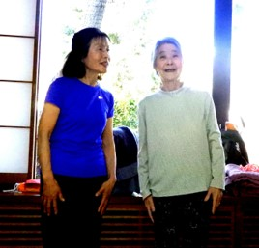 窓側に立っているサークル代表の中村さんと笑顔の高齢の女性の写真