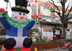 雪だるまのバルーンの後ろに沢山のイルミネーションが飾られてある津田沼一丁目広場の写真