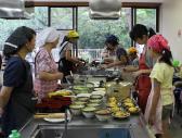 食器や調理器具が並んだ調理台で料理をしている参加者の写真