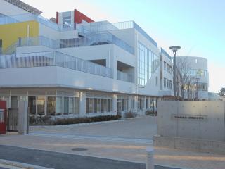 コンクリート白い外壁と窓が沢山ある、新校舎の外観写真