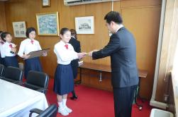 制服姿の女子生徒が市長より受賞される表彰授賞式の写真