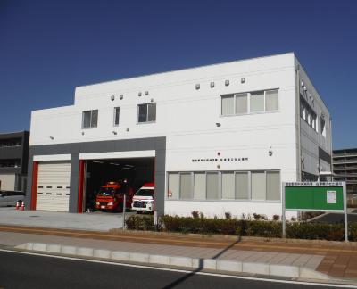 白い外壁で2階建て、車庫に消防車と救急車が1台ずつ停まっている谷津奏の杜出張所の建物の写真
