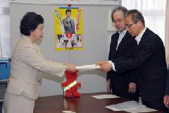 戸谷久子環境生活部長にスーツ姿の男性が要望書を手渡ししている写真