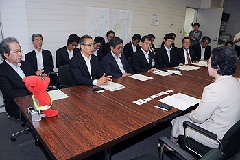 戸谷久子環境生活部長と7市の代表が机を挟んで向い合って座り、話をしている様子の写真