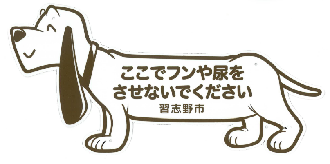 白い犬のイラストに「ここでフンや尿をさせないでください 習志野市」の文字が書かれたマナープレート