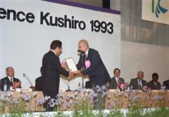 釧路会議の会場の舞台で、登録の受賞を受けている様子の写真