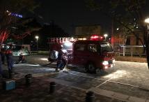 夜にライトを照らしながら消防車の周りで行っている定期訓練の写真