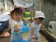 二人ん子どもが水遊びで水に手をのばしている様子
