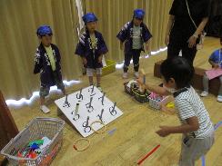 夏のお楽しみ会で子どもたちが輪投げをしている様子