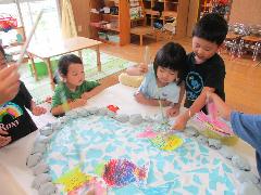 子どもたちが自分で画用紙で作った魚で魚釣りをしている様子