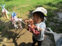 子どもが水遊びで洗濯物を干しているところ