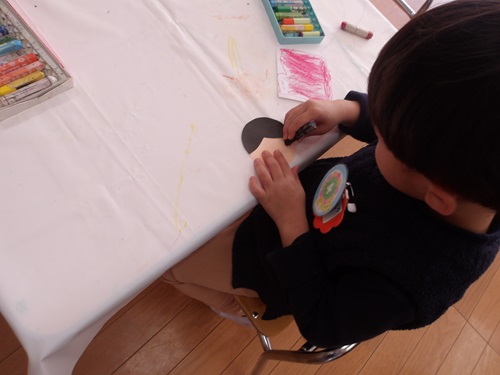 3歳児が雛人形を作ろうとクレヨンで顔を描いている様子