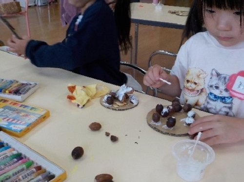 4歳児がどんぐりを使って制作を楽しむ様子