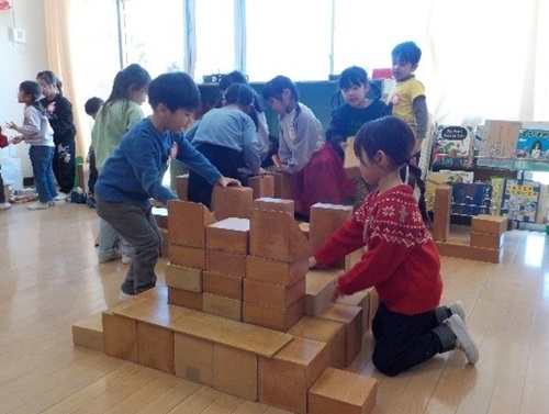 4歳児が友達と一緒に箱積木を組み立てて楽しんでいる様子