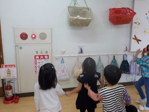 4歳児が廊下で玉入れ遊びをしている