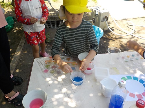 色水を混ぜて色の移り変わりを楽しむ5歳児