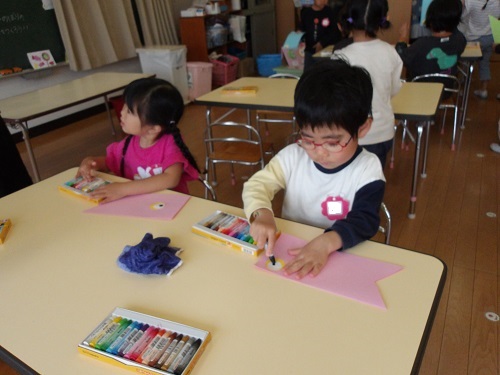 4歳児がクレヨンでこいのぼりの目を描いているところ