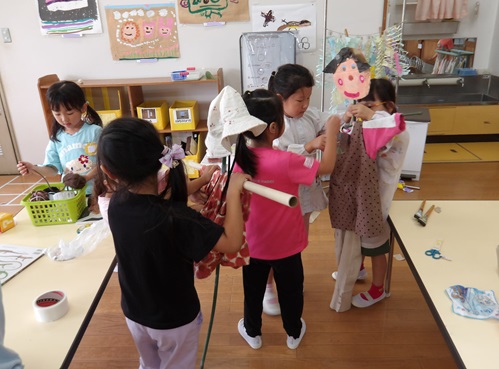 5歳児が友達と協力してかかしを作っている。