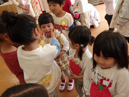 5歳児が3歳児にプレゼントを渡しているところ