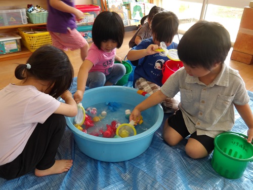 3歳児が室内で水遊びをしている