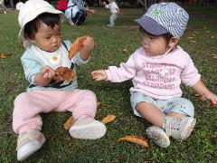 葉っぱを手に取る0歳児