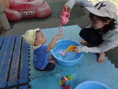 0才児がじょうろの水を楽しむところ