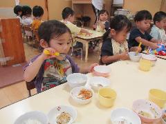 手でお皿を抑えながら給食を食べている様子