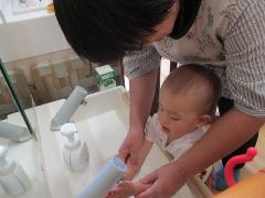 0歳児が食事前に手を洗っているところ