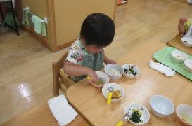 1歳児が自分でスプーンを持ち食事をしているところ