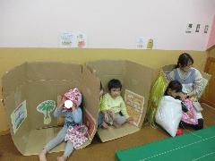 2歳児がダンボールで作った家に入って遊んでいるところ