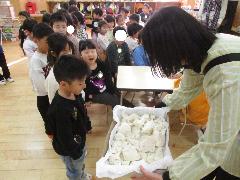 4歳児が、5歳児が開いた鏡餅を見せてもらっているところ