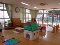 手作りの子供が入って遊べるサイズの家やテーブル、ブロックが置かれている、にこにこルームの写真