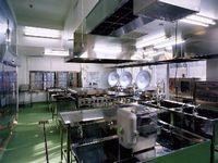 業務用の大きな鍋などが設置された調理室の写真