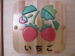 赤色の2つのイチゴの絵が描かれたいちご組の木製プレートの写真