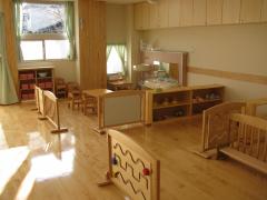 仕切りや棚、テーブルなどが木製で作られている1歳児のお部屋の写真