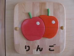 赤色とオレンジ色の2つのりんごの絵が描かれた、りんご組の木製プレートの写真
