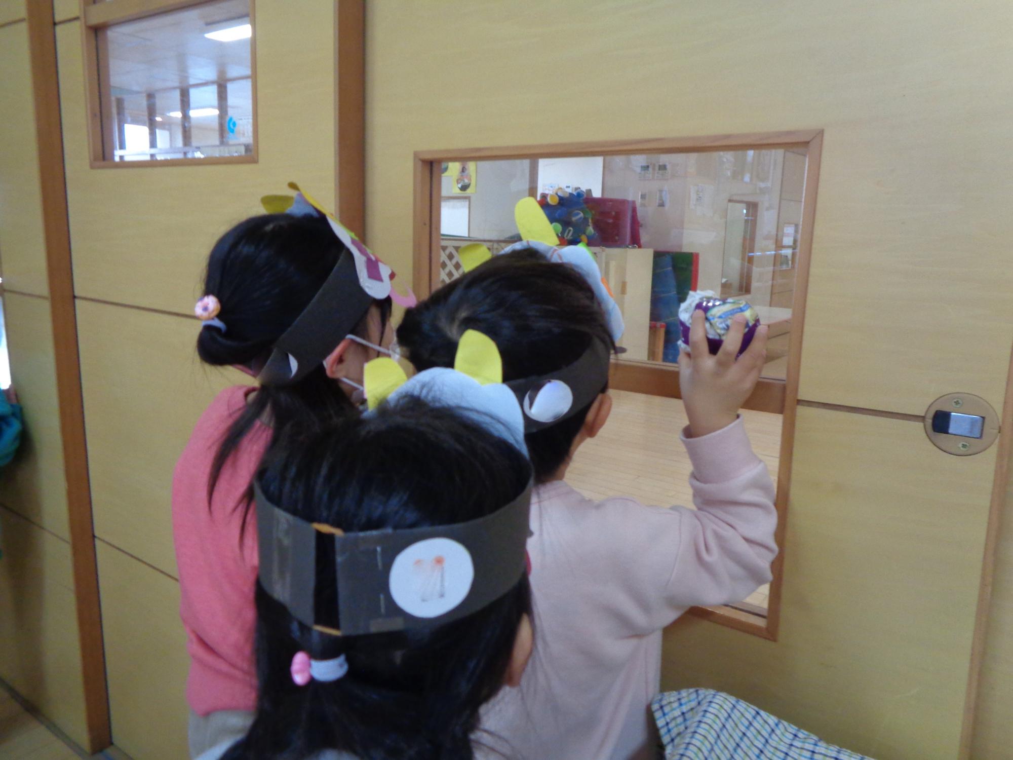 3歳児鬼が来ないか室内から廊下を見ている