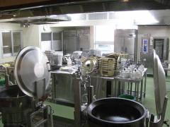 業務用の調理器具や釜などが設置されている調理室内の写真