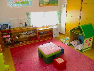 杉の子こども園の室内にあるちゃぶ台や様々なおもちゃの調理器具が置かれてあるままごとコーナーの写真