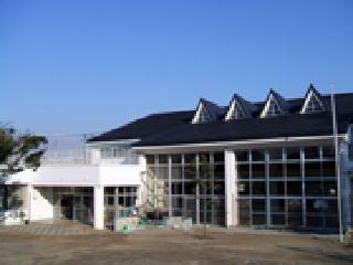 園舎の前に園庭が広がり、三角屋根をした秋津保育所の外観写真
