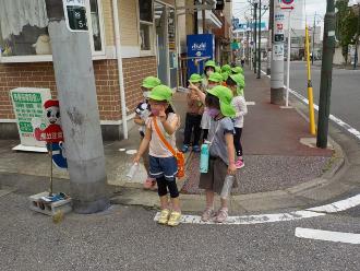 道路の角で左右を確認して渡ろうとしている子供たちの写真