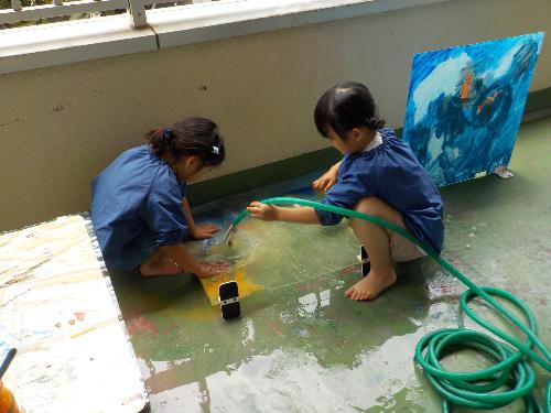 ホースを使って水を流しアクリル板を洗っています