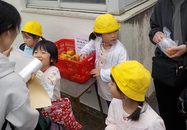 園庭の柿が豊作でした。帰りに各家庭におすそ分けしているところです。