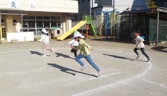 津田沼幼稚園の園庭で鬼ごっこを楽しんでいます。