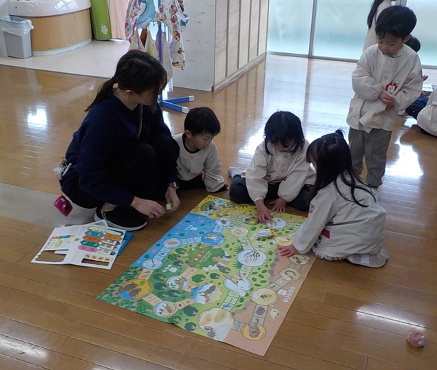 お正月遊びでクラスの友達とすごろくを楽しんでいるところ
