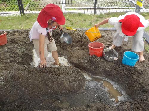 砂場に水を流して遊んでいます