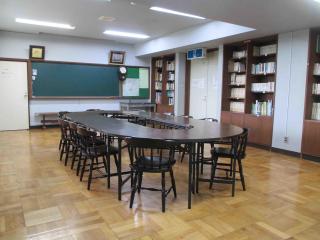 O型のテーブルに椅子が並んで設置されている研修室の写真